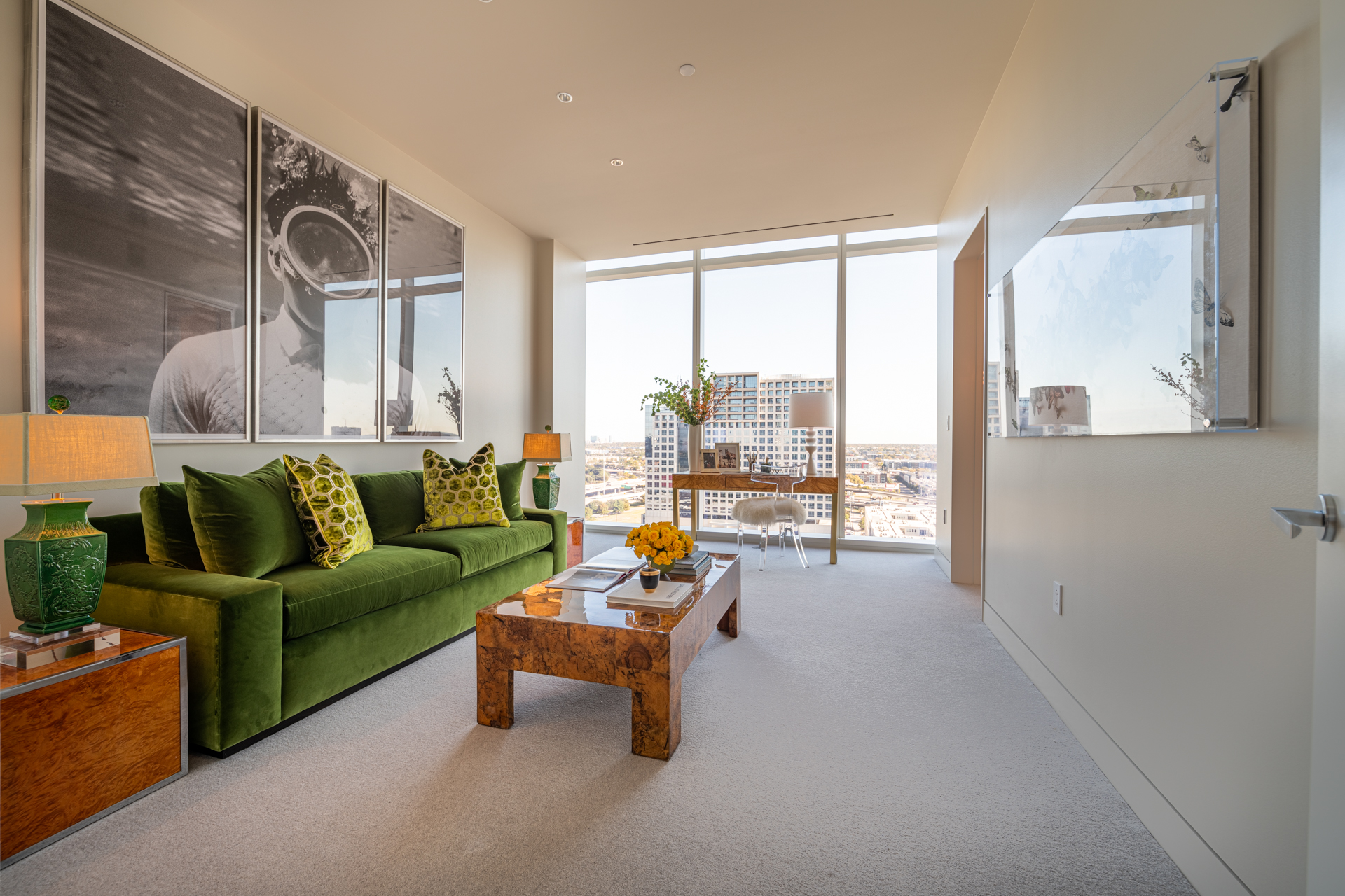 Room with green couch and desk with city views.