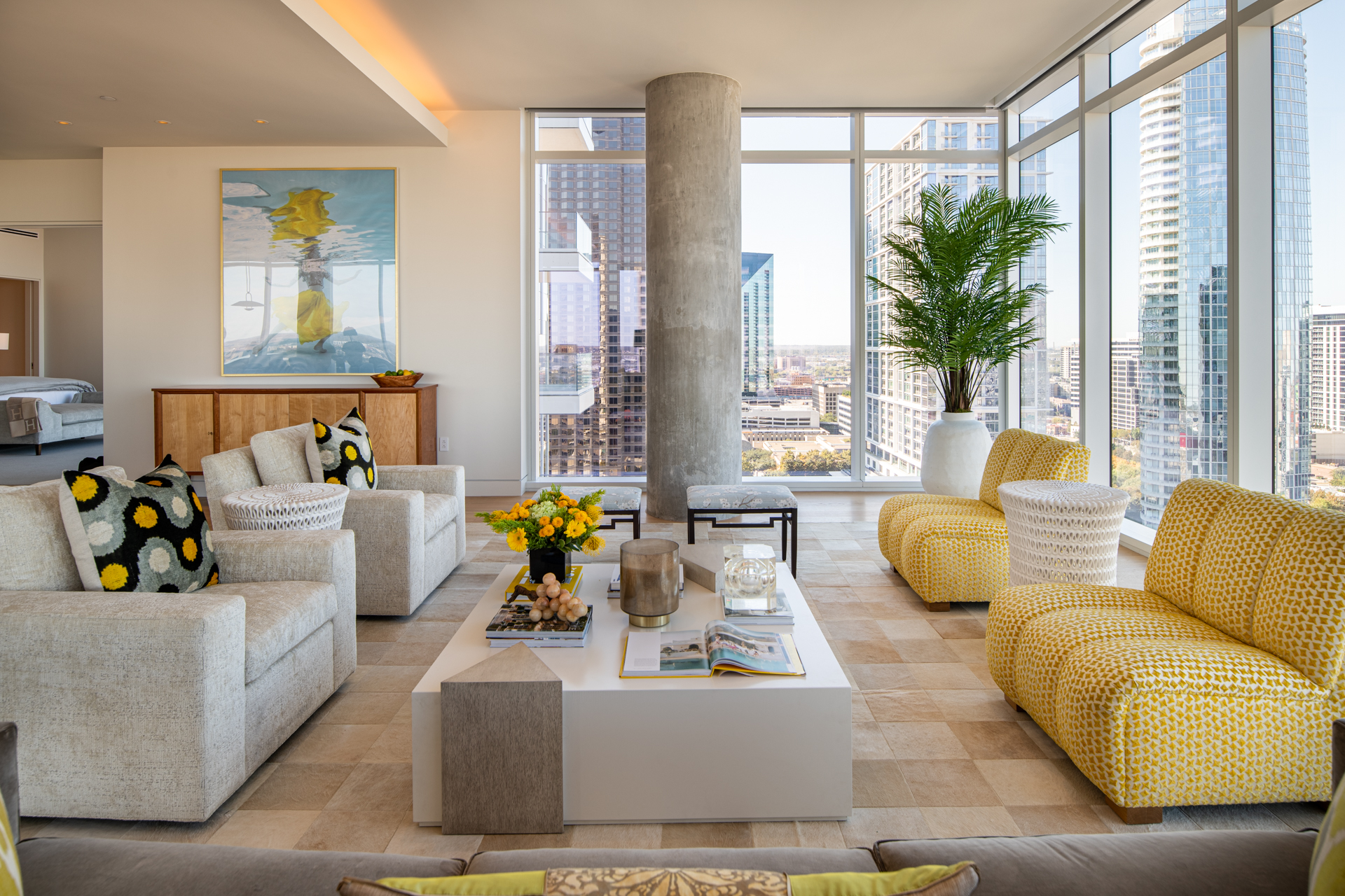 Living room with yellow and grey furniture and city views.